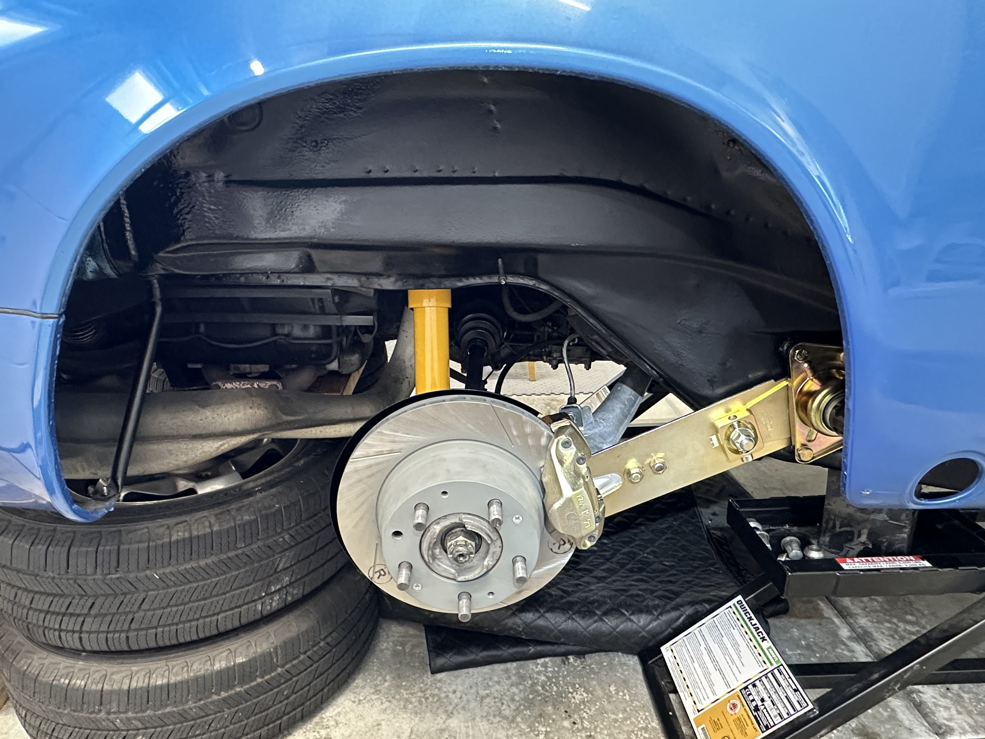 Suspension and brake upgrades installed under the rear fender of the Porsche 912E